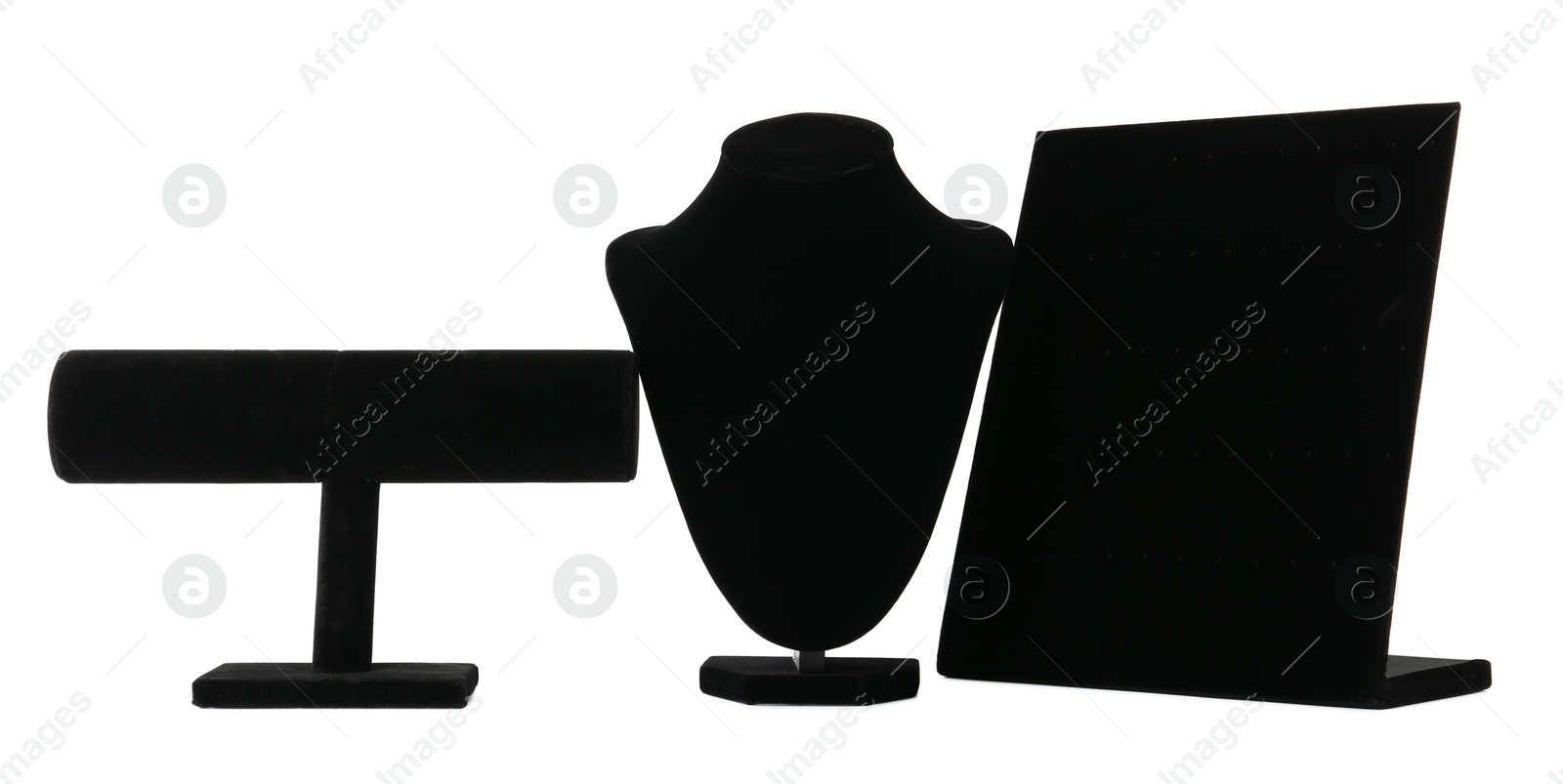 Photo of Different empty black velvet jewelry stands on white background