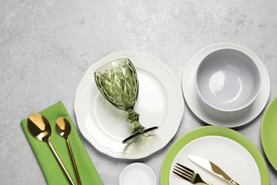 Photo of Beautiful ceramic dishware, glass and cutlery on light grey table, flat lay