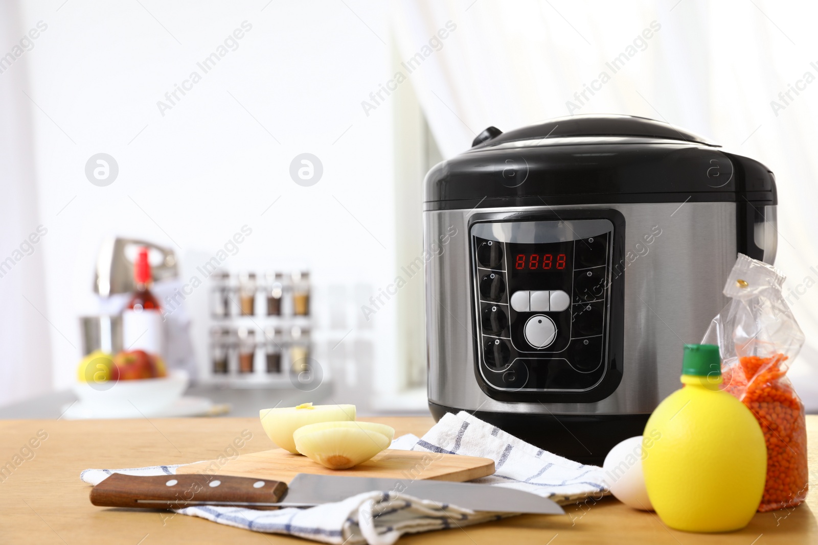 Photo of New modern multi cooker and products on table in kitchen. Space for text