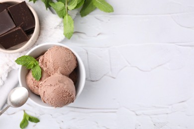 Photo of Bowl with tasty chocolate ice cream and mint leaves on white table, flat lay. Space for text