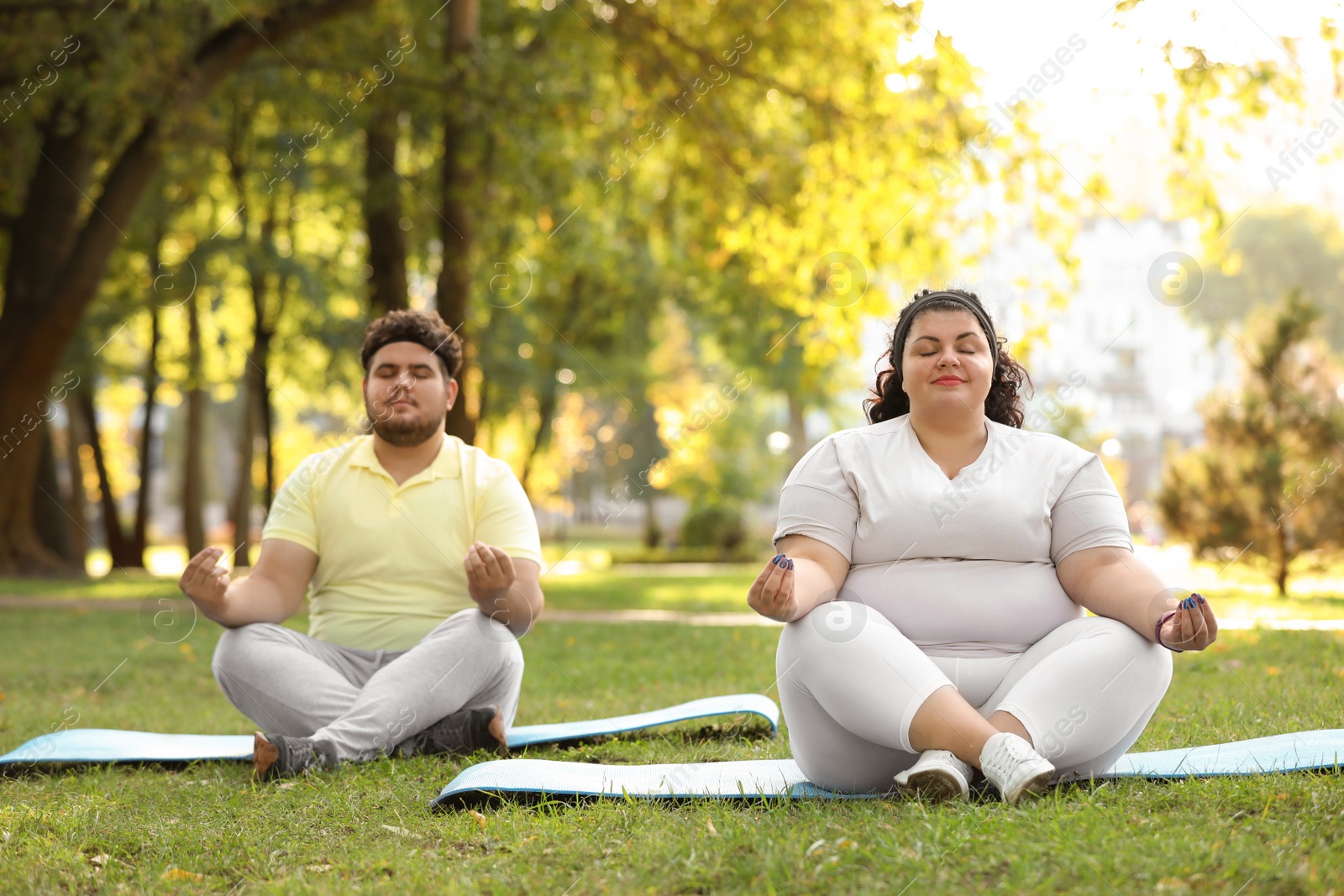 Photo of Overweight couple training together in park on sunny day