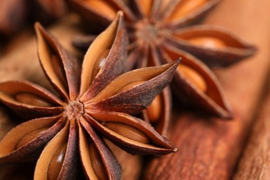 Aromatic anise stars on cinnamon sticks as background, closeup