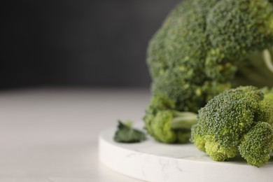 Photo of Fresh raw broccoli on white table, closeup. Space for text