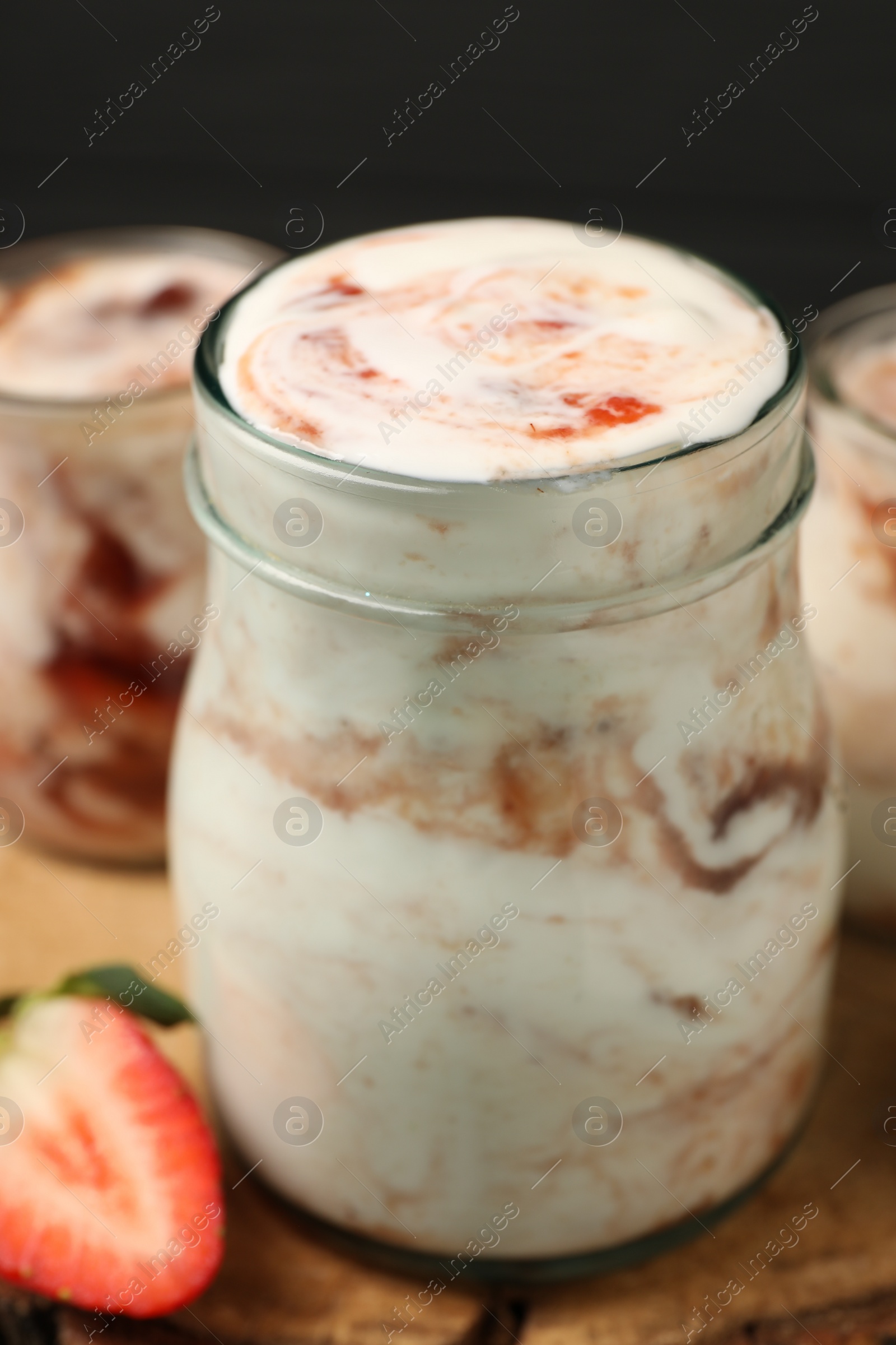 Photo of Tasty yoghurt with jam and strawberry on table, closeup