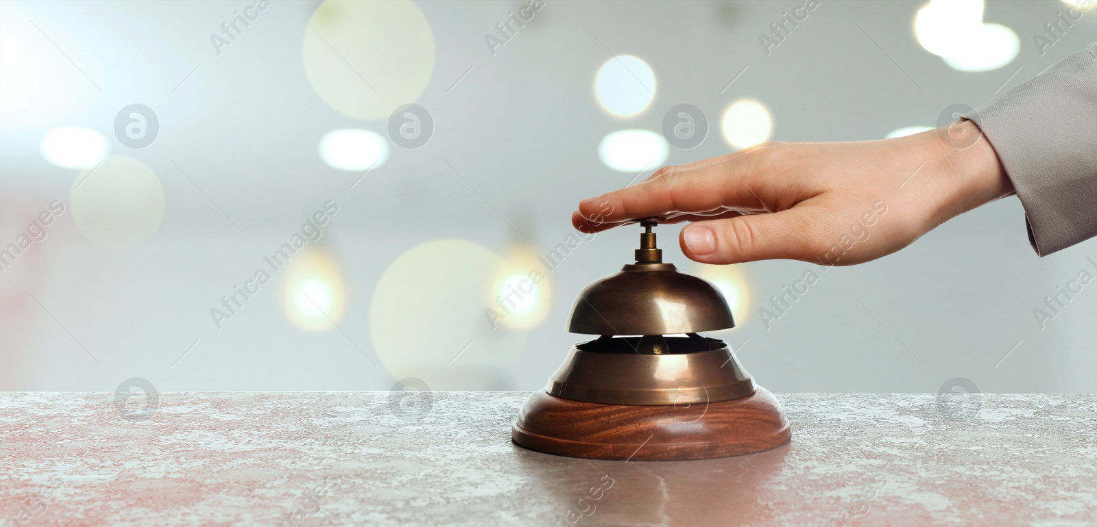 Image of Woman ringing hotel service bell on blurred background, closeup. Banner design