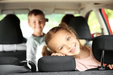 Photo of Cute children in car. Happy family taking road trip