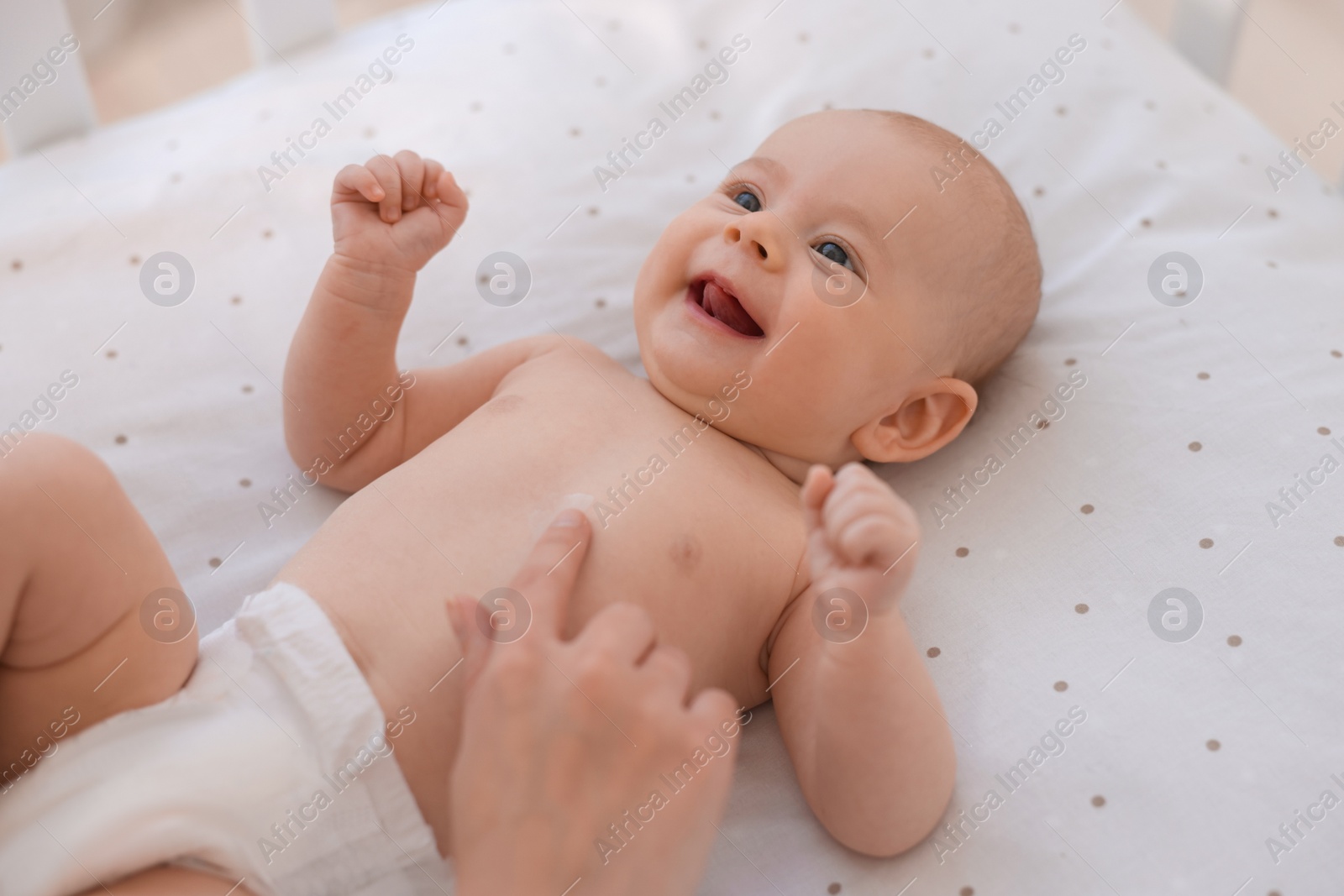 Photo of Mother with her cute little baby in crib