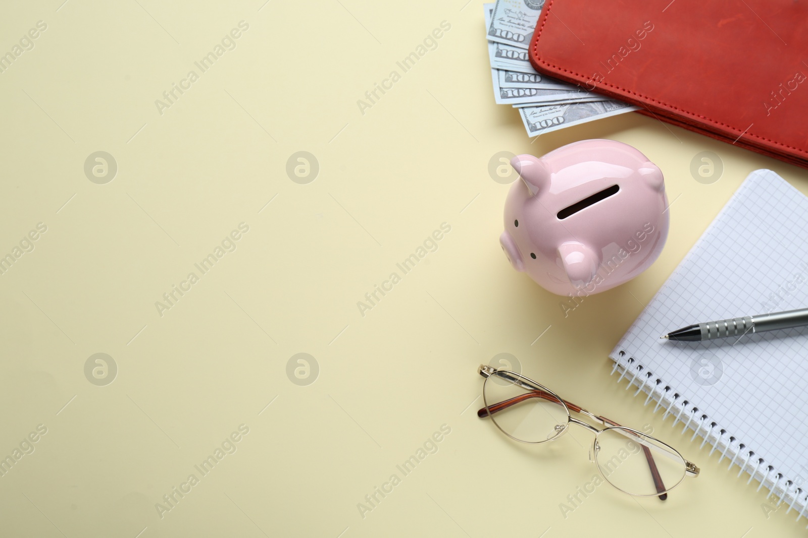 Photo of Flat lay composition with piggy bank, banknotes and glasses on beige background. Space for text