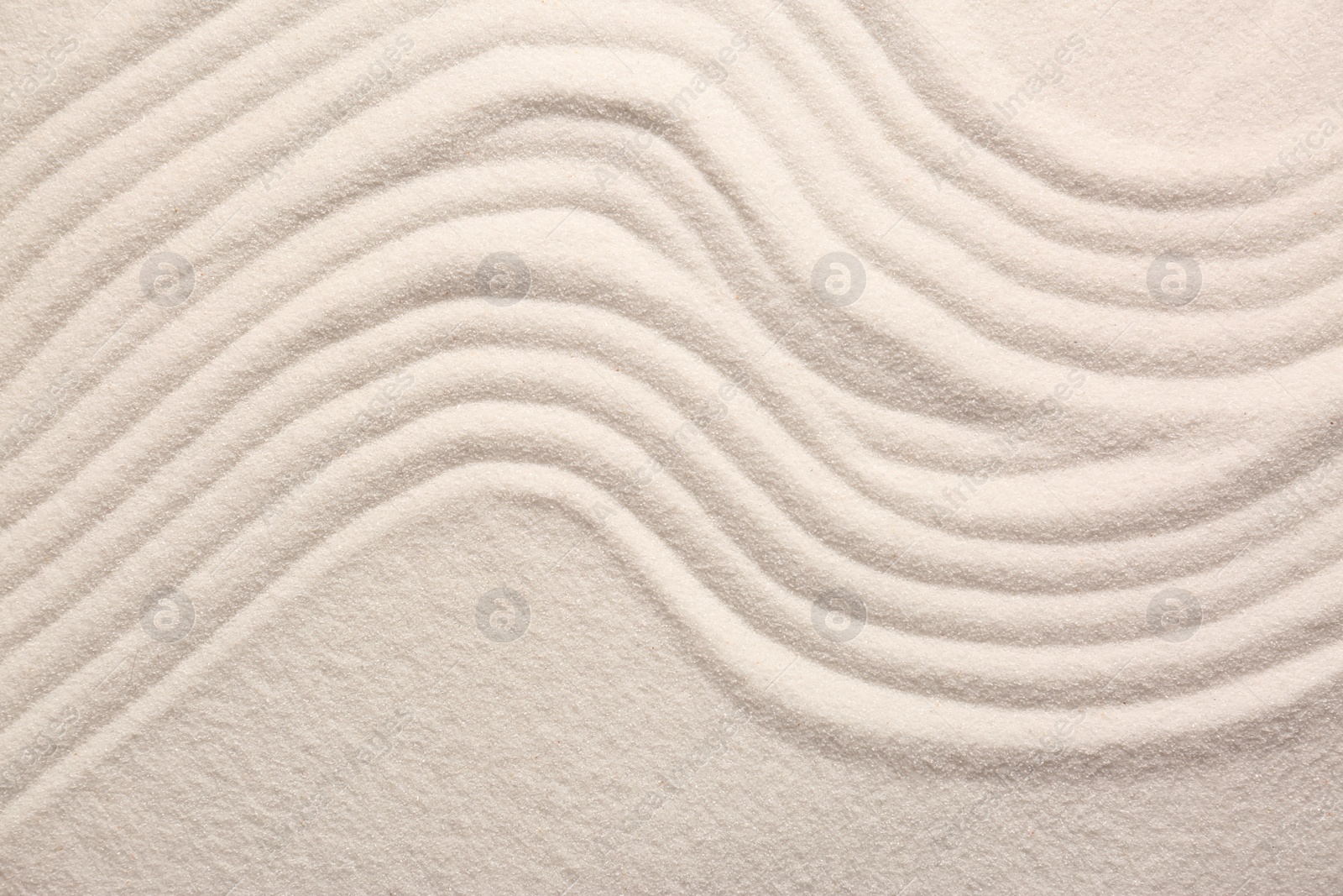 Photo of White sand with pattern as background, top view. Zen concept