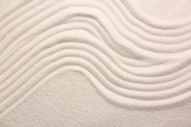 Photo of White sand with pattern as background, top view. Zen concept
