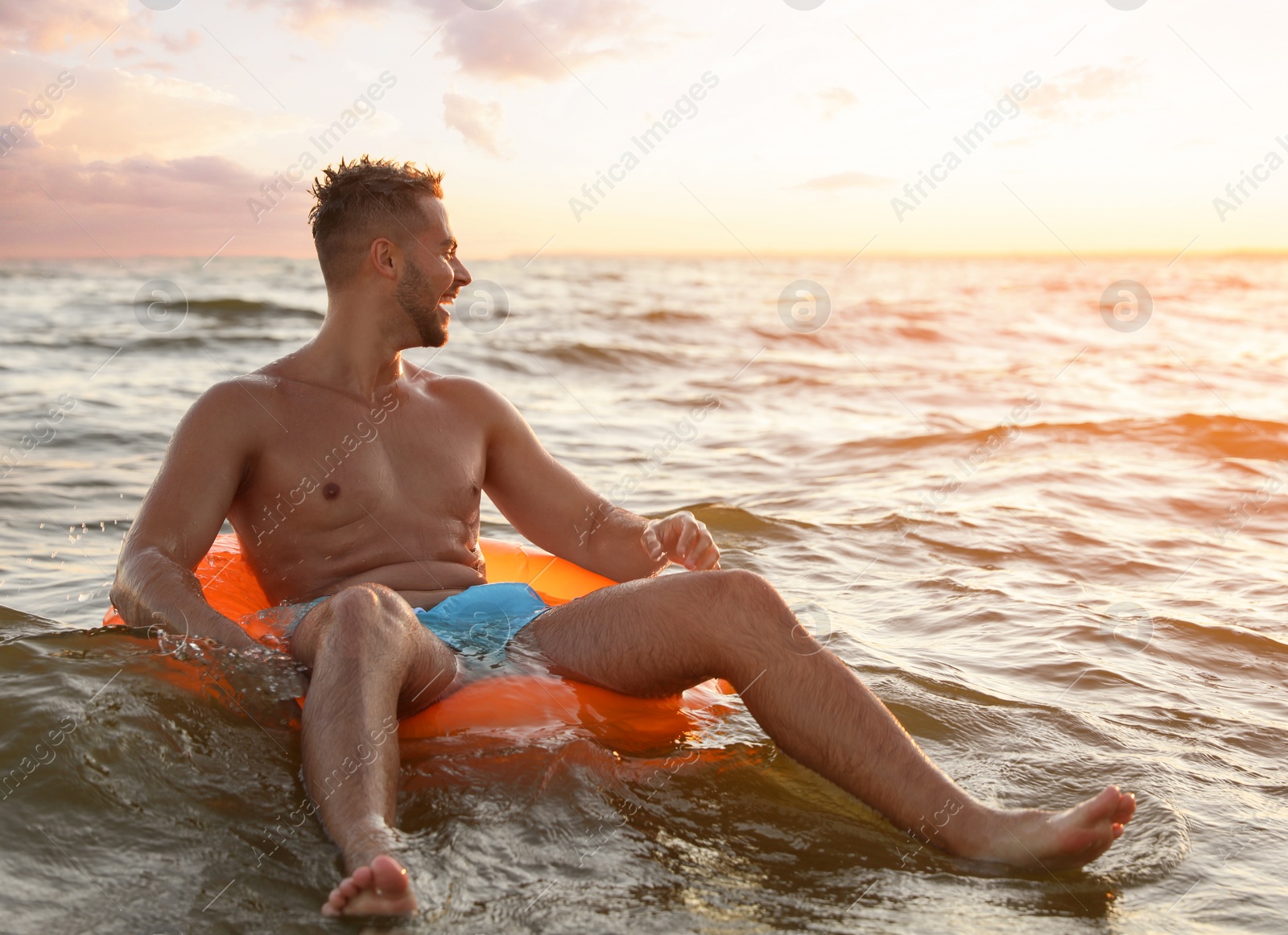 Photo of Happy young man on inflatable ring in water