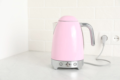 Photo of Modern electric kettle on counter in kitchen