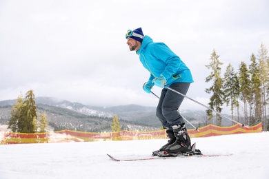 Photo of Male skier on slope at resort, space for text. Winter vacation