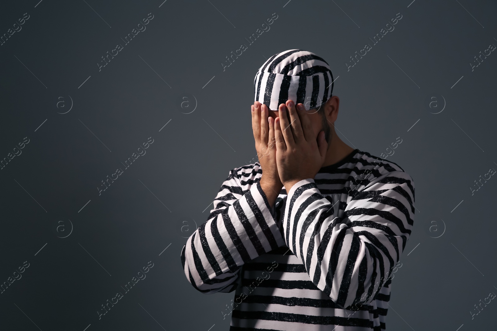 Photo of Prisoner in special uniform on dark grey background, space for text