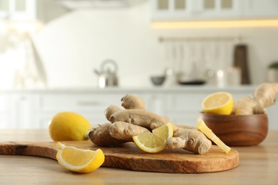 Photo of Fresh lemons and ginger on wooden table indoors, space for text