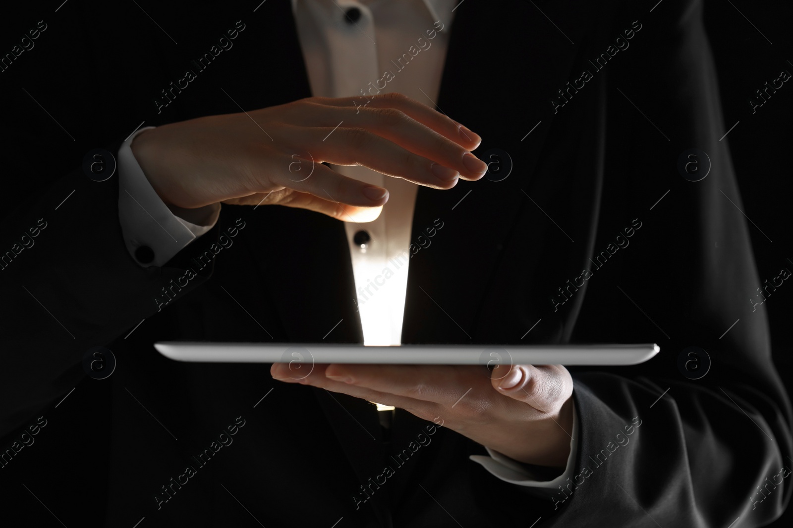 Photo of Closeup view of man using modern tablet on black background