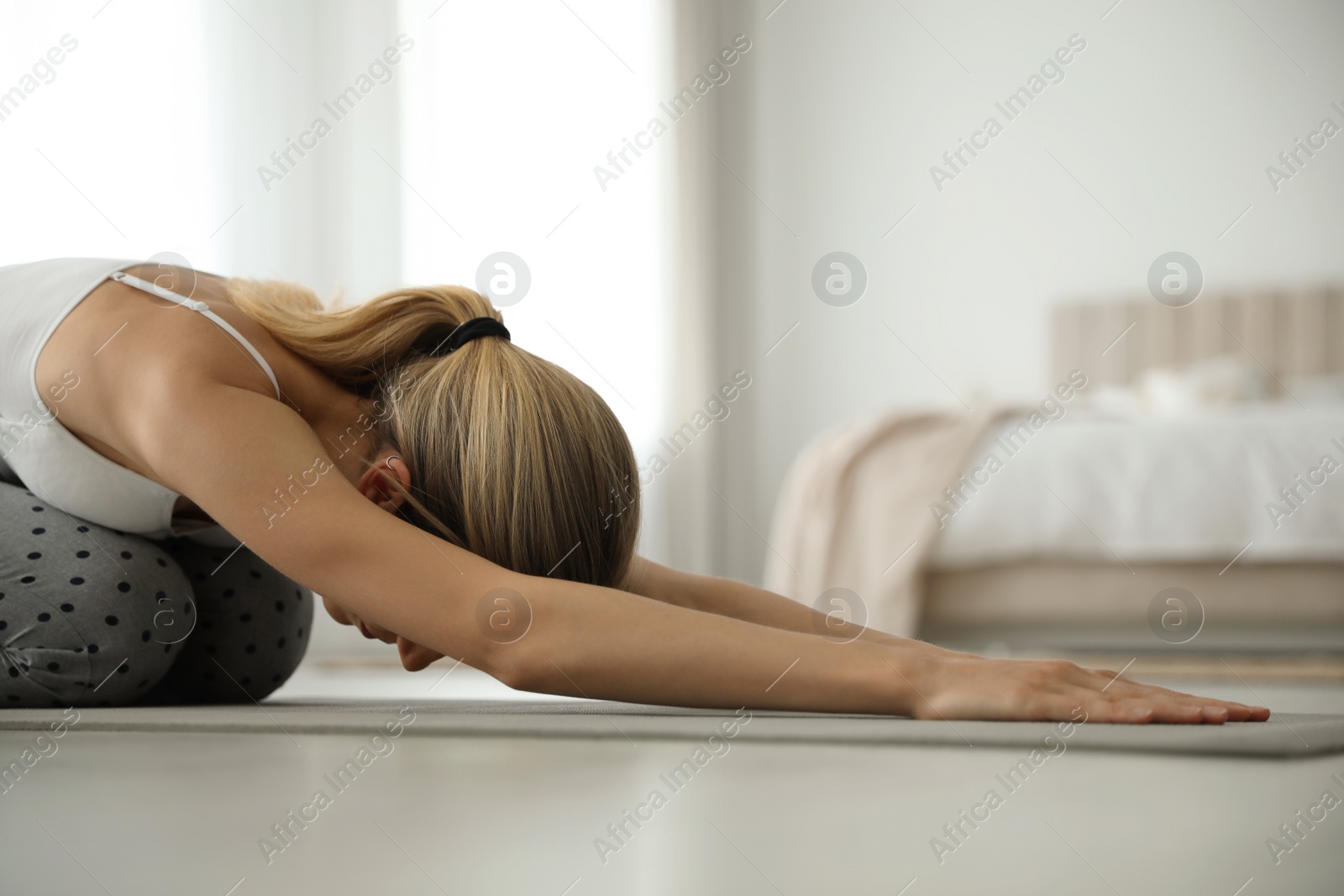 Photo of Young woman doing gymnastics on floor at home. Morning fitness