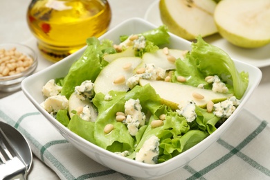 Photo of Fresh salad with pear served on table, closeup