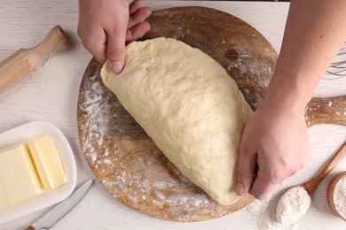 Photo of Man kneading dough at white wooden table, top view