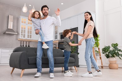 Photo of Happy family dancing and having fun at home, low angle view