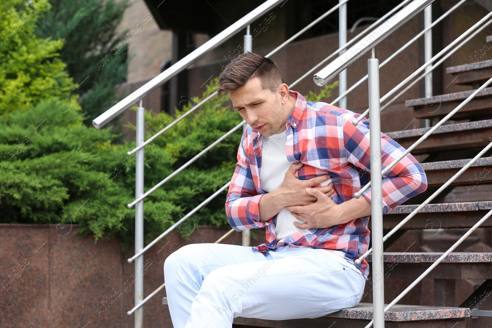 Photo of Young man having chest pain outdoors. Heart attack