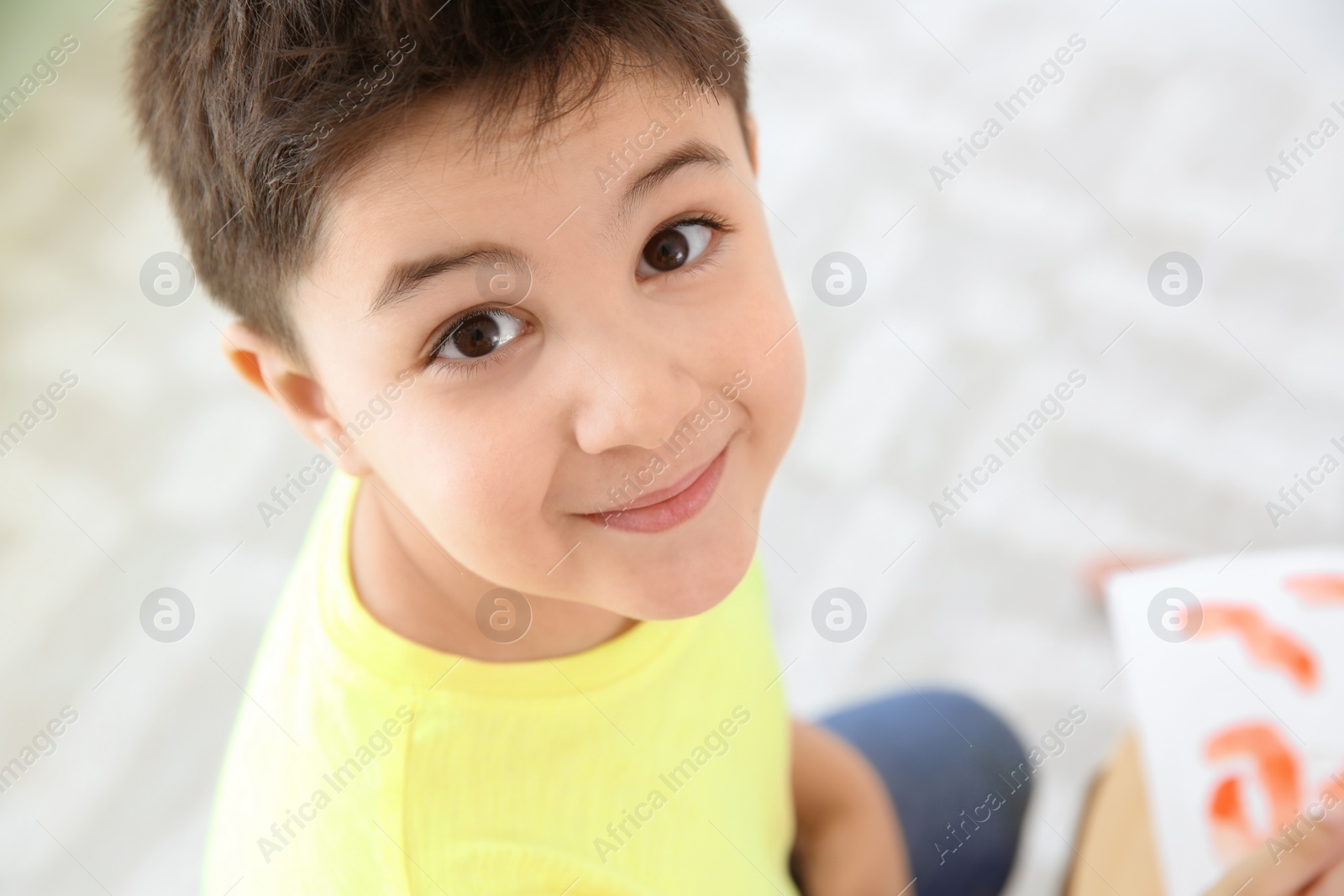 Photo of Cute little child painting in playing room, closeup