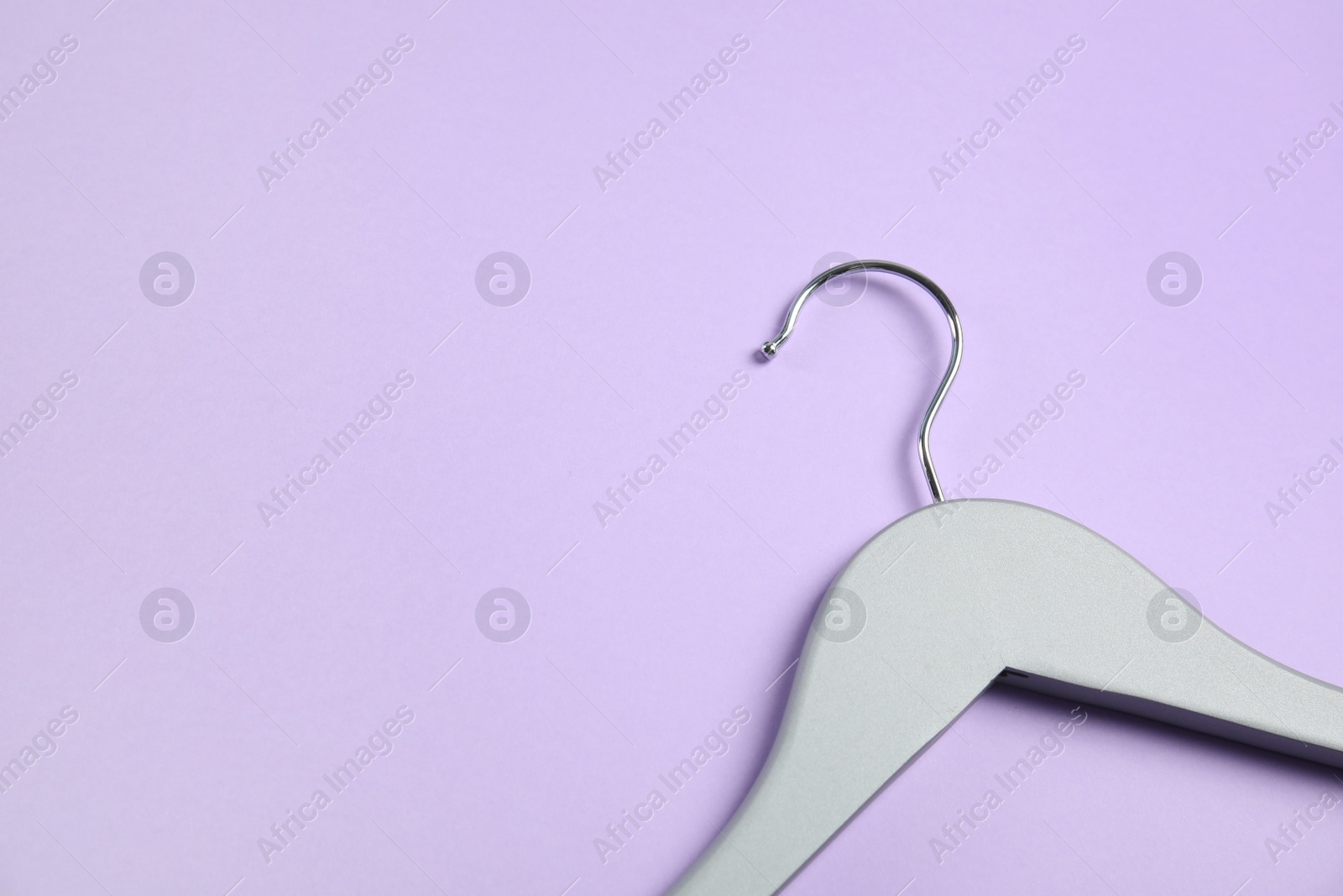 Photo of Empty wooden clothes hanger on color background. Space for text