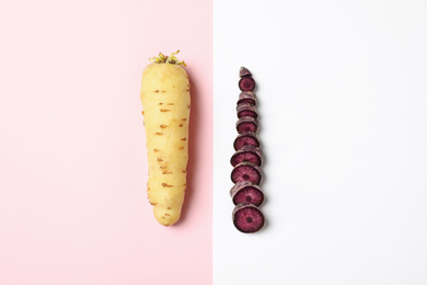 Photo of Raw white and purple carrots on color background, flat lay