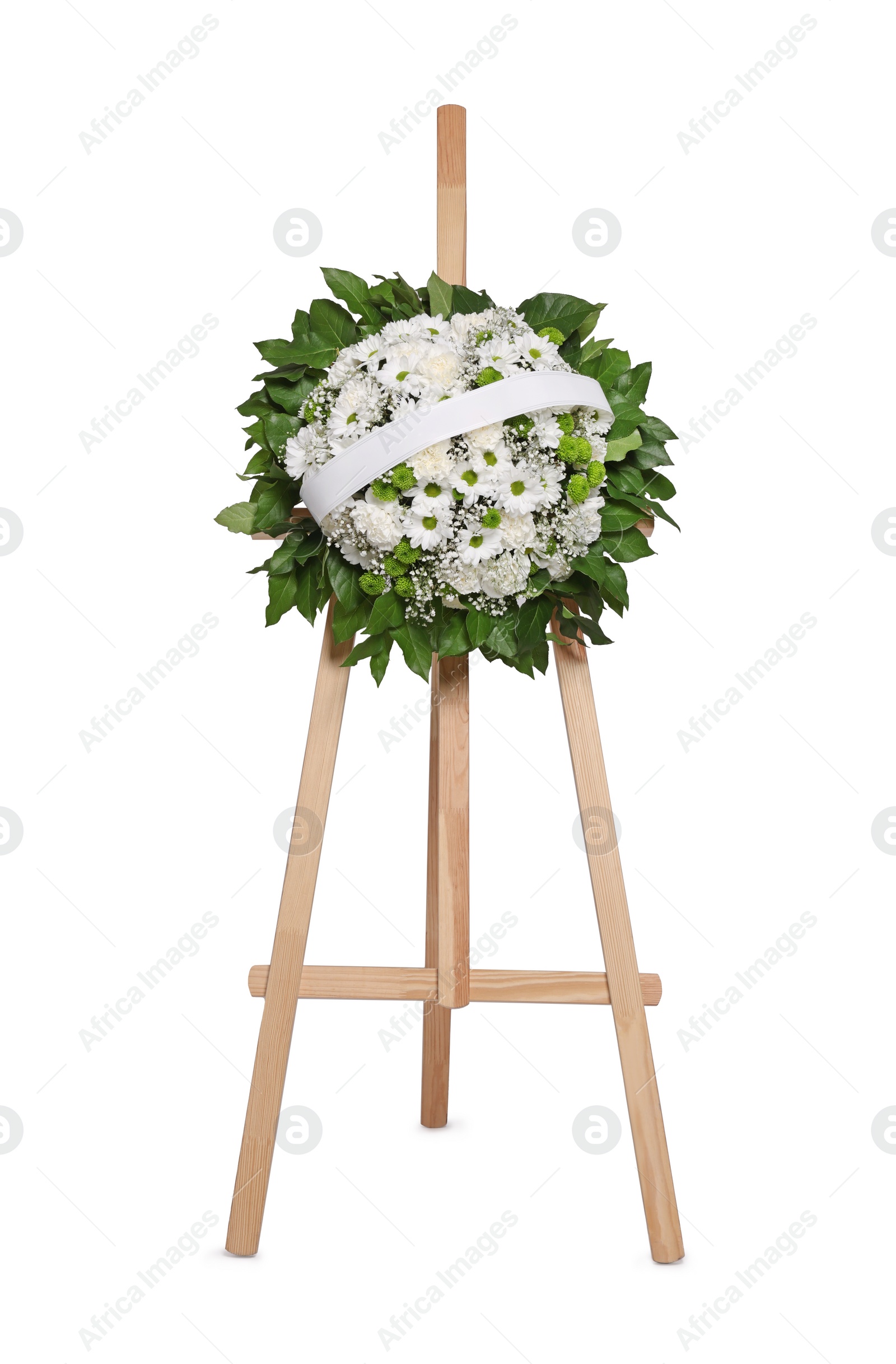 Photo of Funeral wreath of flowers with ribbon on wooden stand against white background