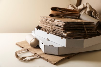 Stack of different waste paper on beige background, closeup