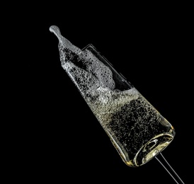 Photo of Glass of champagne on black background. Festive drink