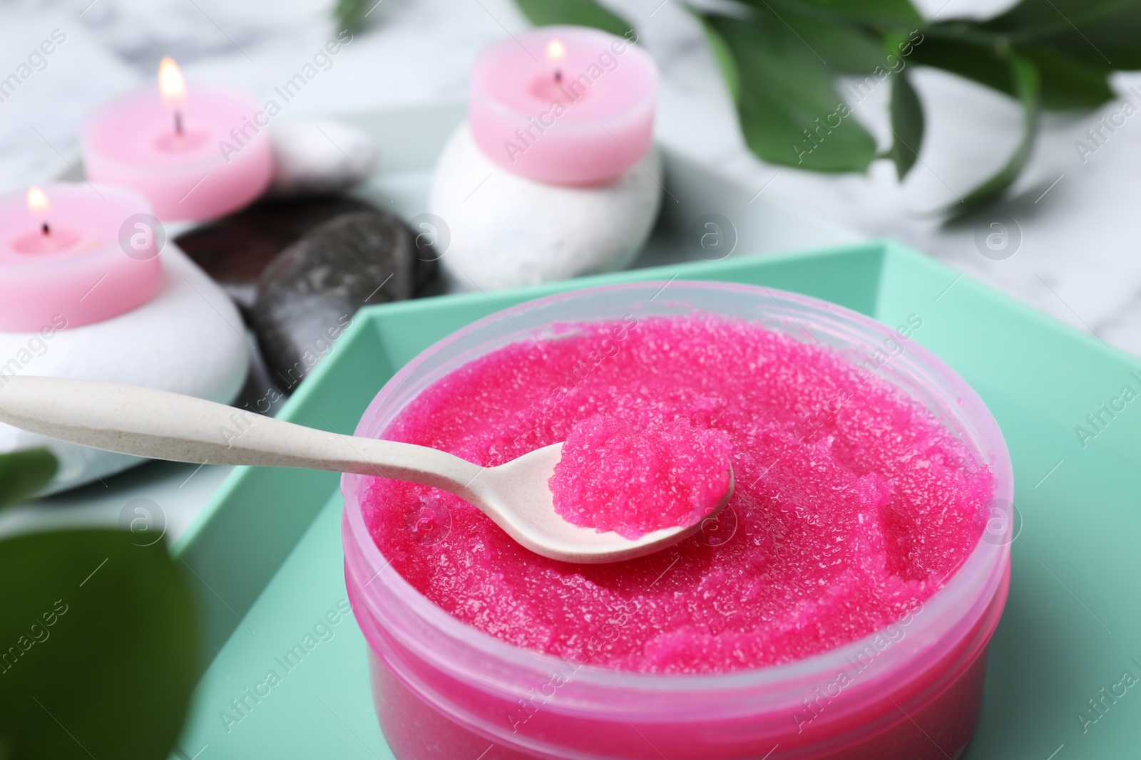 Photo of Spa composition with scrub, spa stones and candles on table, closeup