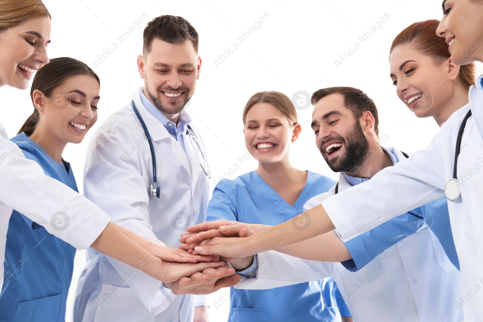 Photo of Team of medical doctors putting hands together on white background. Unity concept