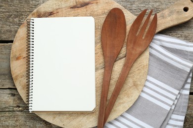 Blank recipe book and kitchen utensils on old wooden table, flat lay. Space for text