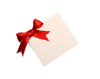 Photo of Blank gift tag with satin ribbon on white background, top view