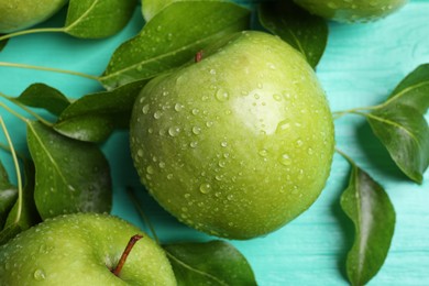 Fresh ripe green apples with water drops on turquoise wooden table, flat lay