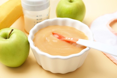 Bowl of healthy baby food on color background