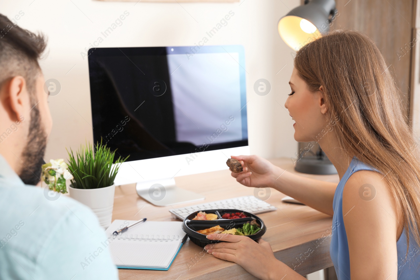 Photo of Office employees having lunch at workplace. Food delivery