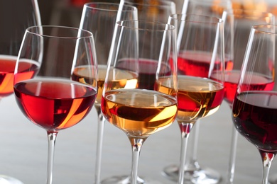 Photo of Glasses with different wines on blurred background, closeup