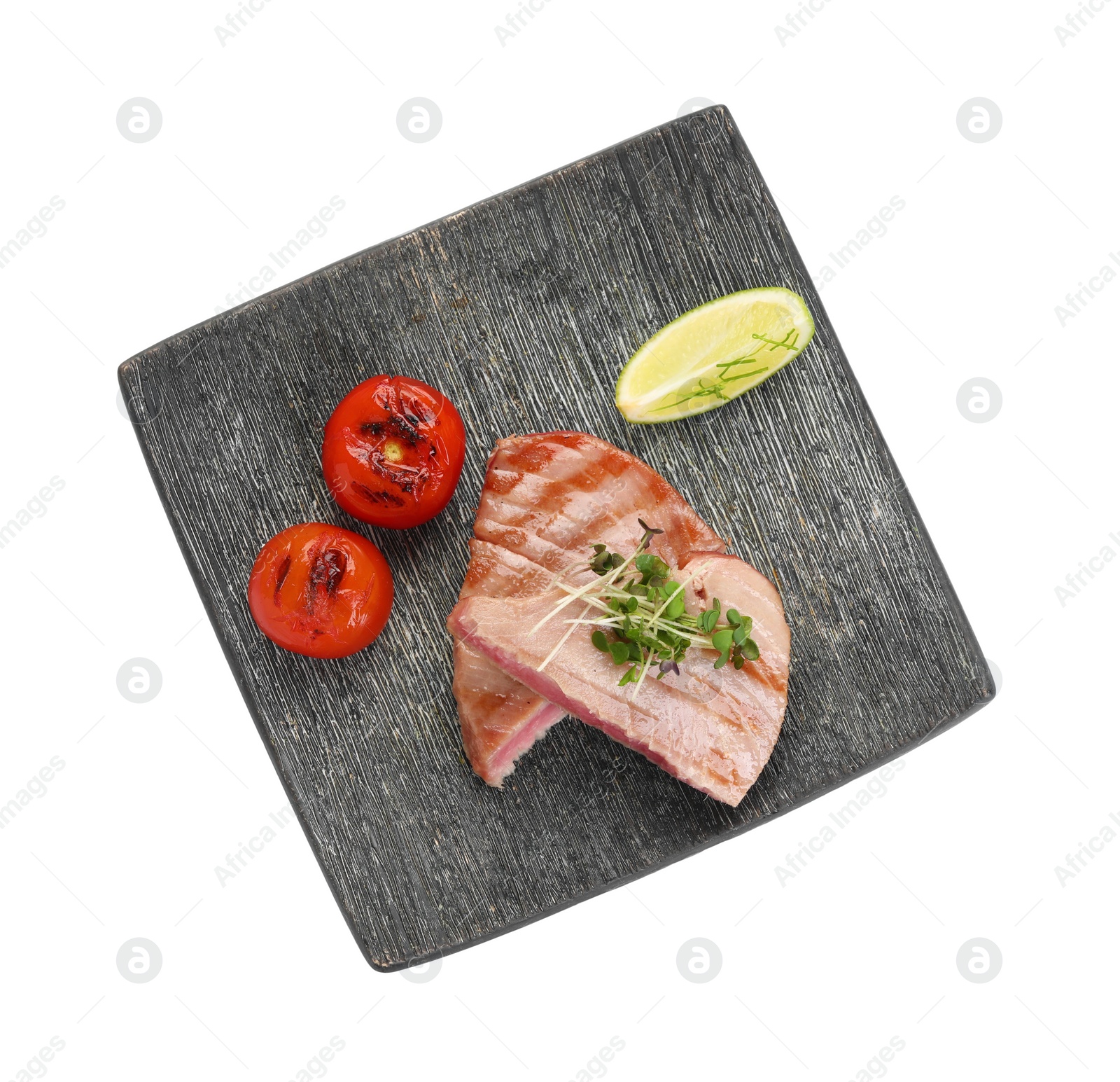 Photo of Pieces of delicious tuna with microgreens, lime and tomatoes on white background, top view