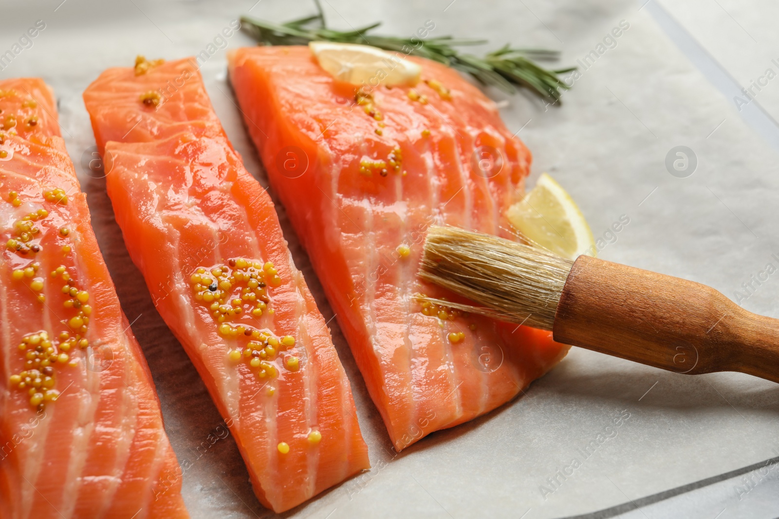 Photo of Fresh salmon with mustard on parchment, closeup