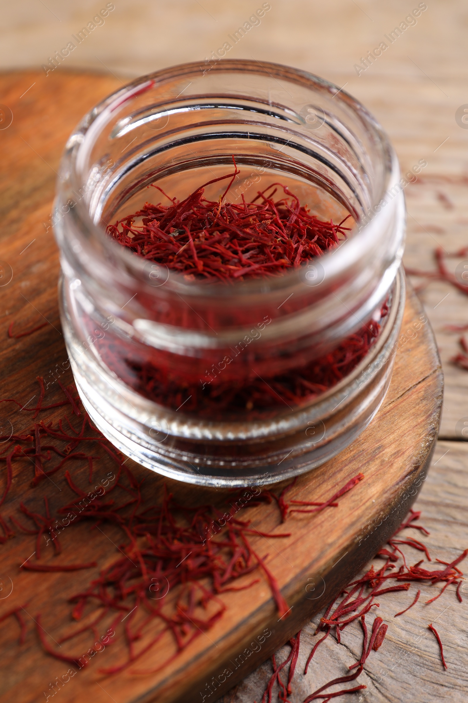 Photo of Aromatic saffron in glass jar on table, closeup