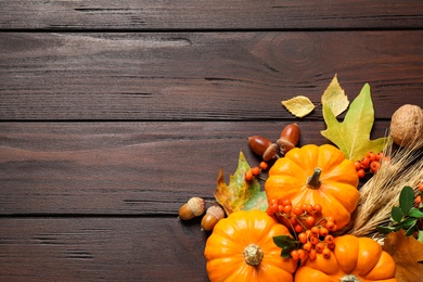 Photo of Flat lay composition with vegetables, berries and autumn leaves on wooden table, space for text. Thanksgiving Day