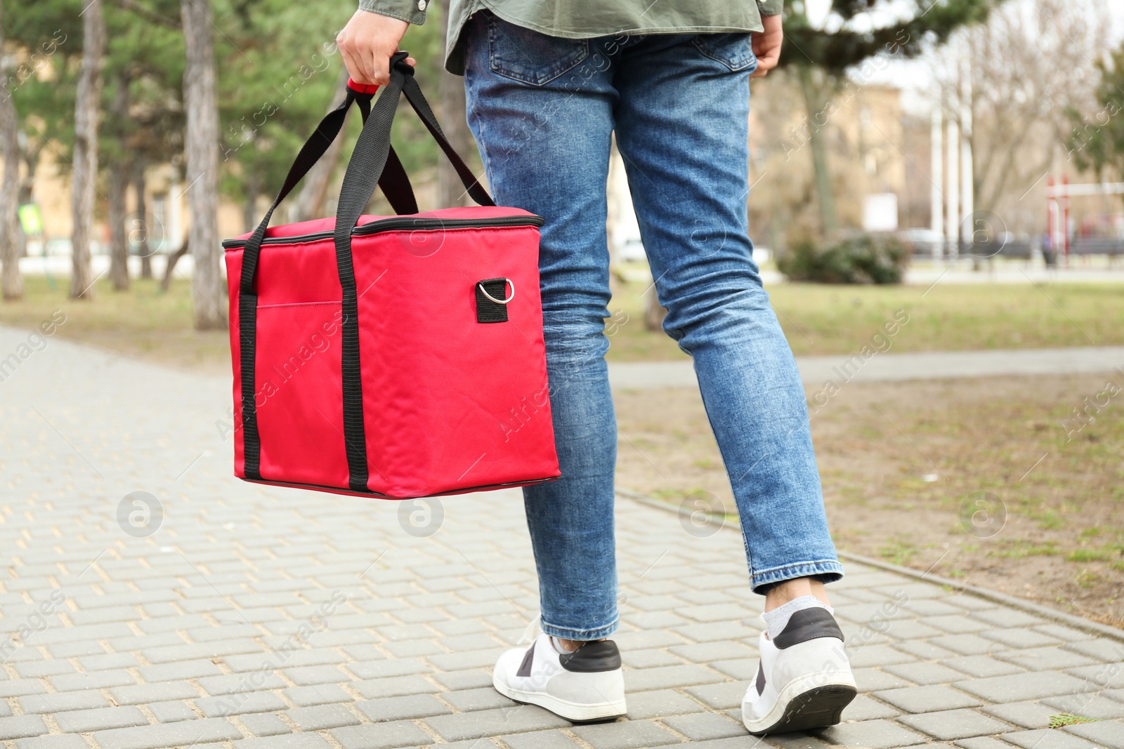 Photo of Courier with thermo bag outdoors, closeup. Food delivery service