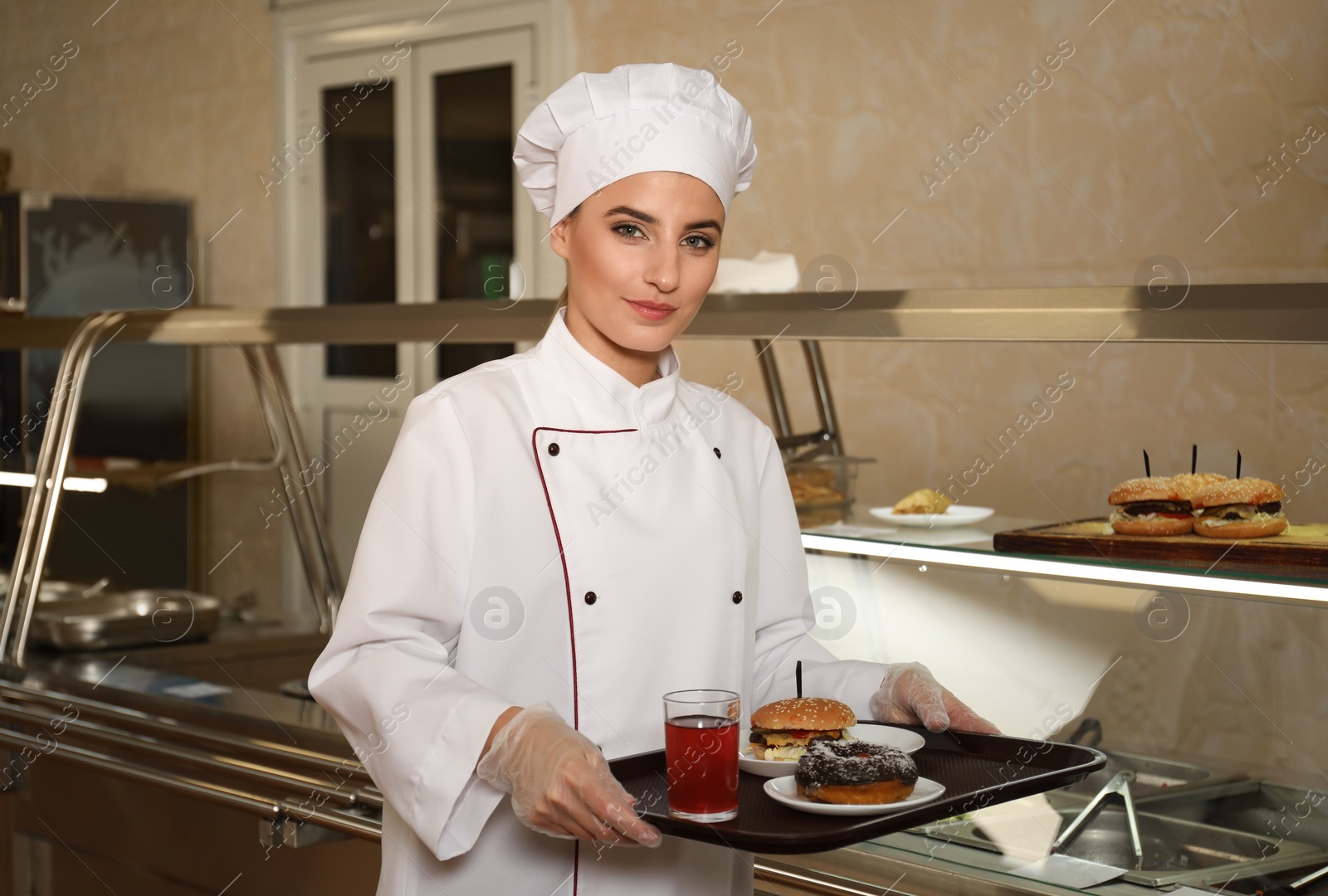 Photo of School canteen worker with tasty food near serving line