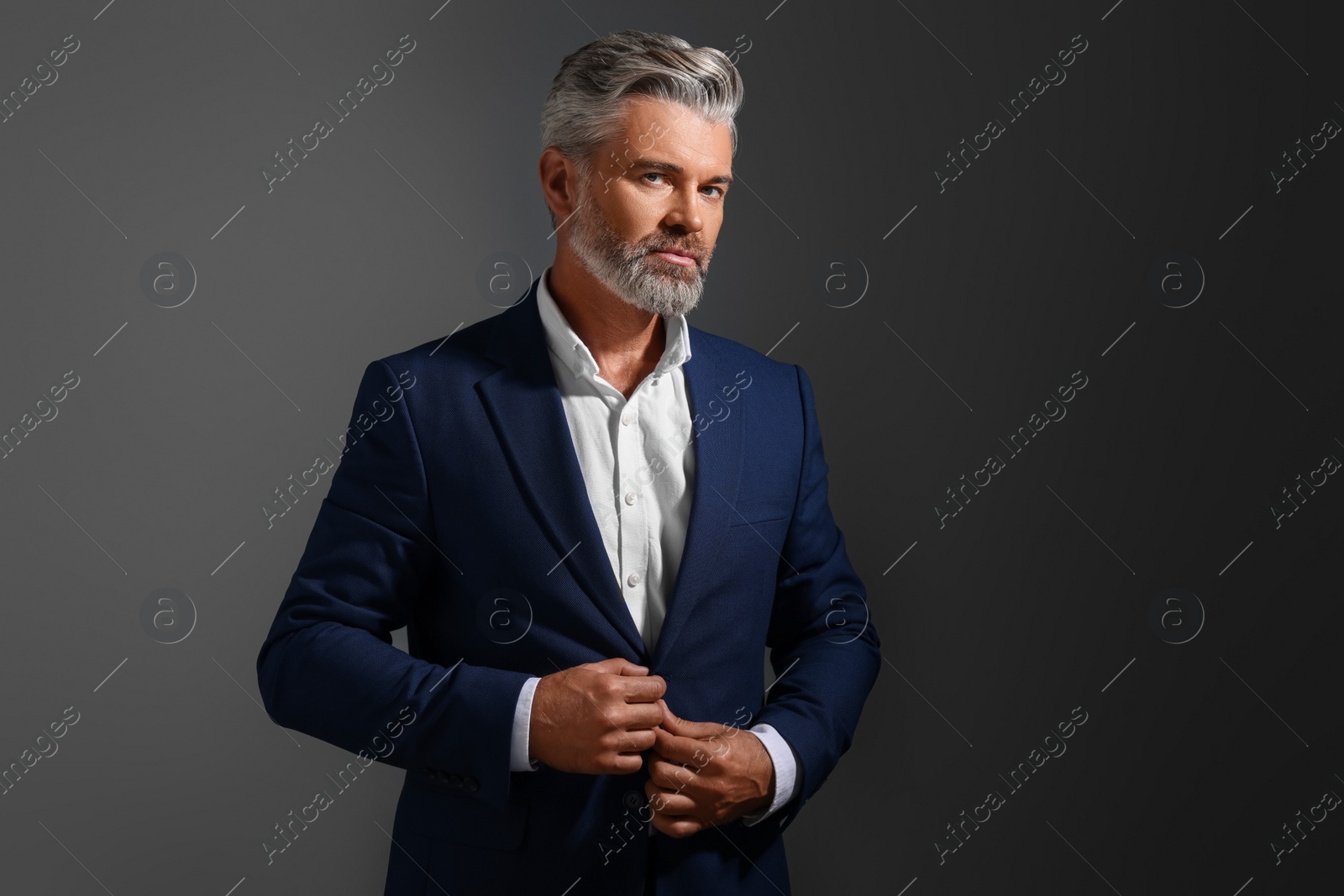 Photo of Portrait of confident man with beautiful hairstyle on dark background