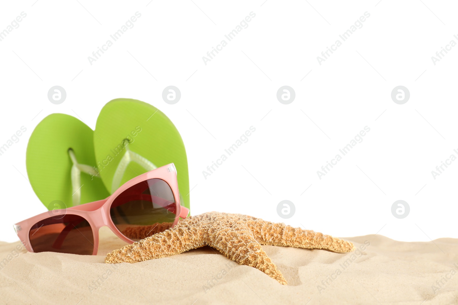 Photo of Beach accessories on sand against white background. Space for text