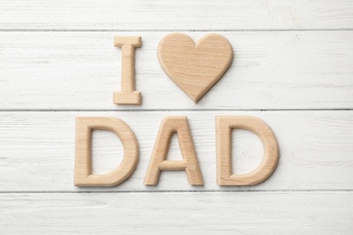 Photo of Words I LOVE DAD made from wooden letters on white table, flat lay