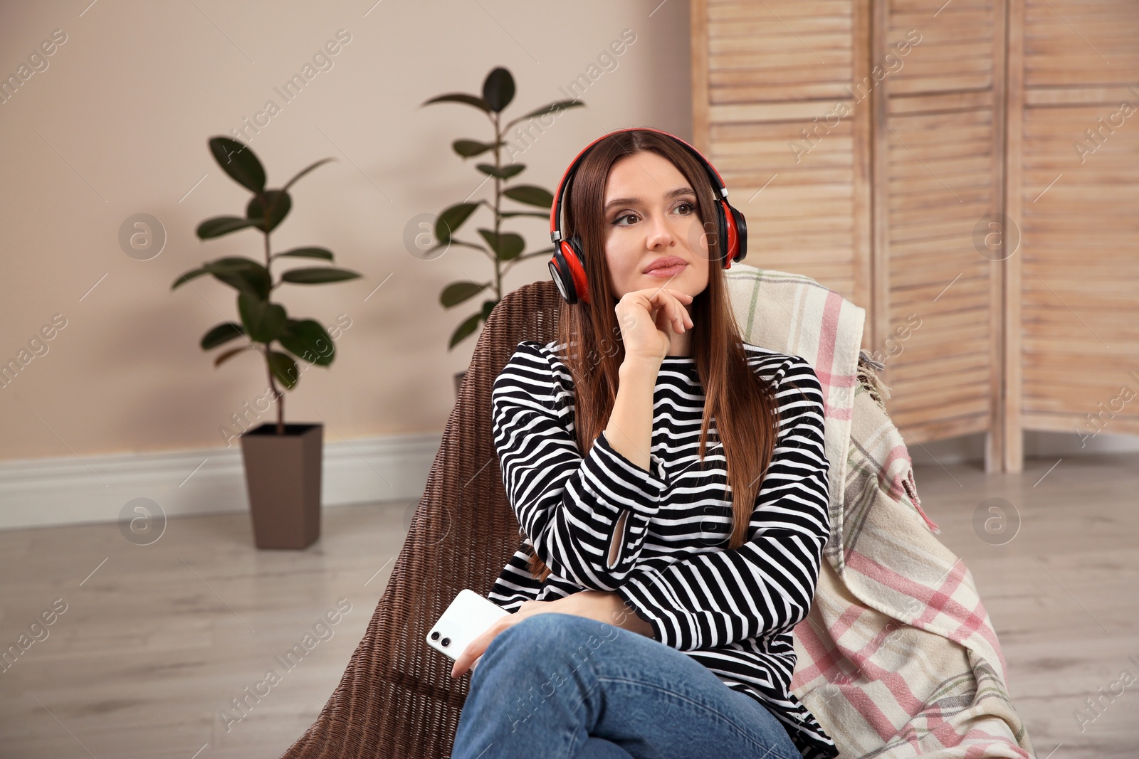 Photo of Woman listening to audiobook in chair at home