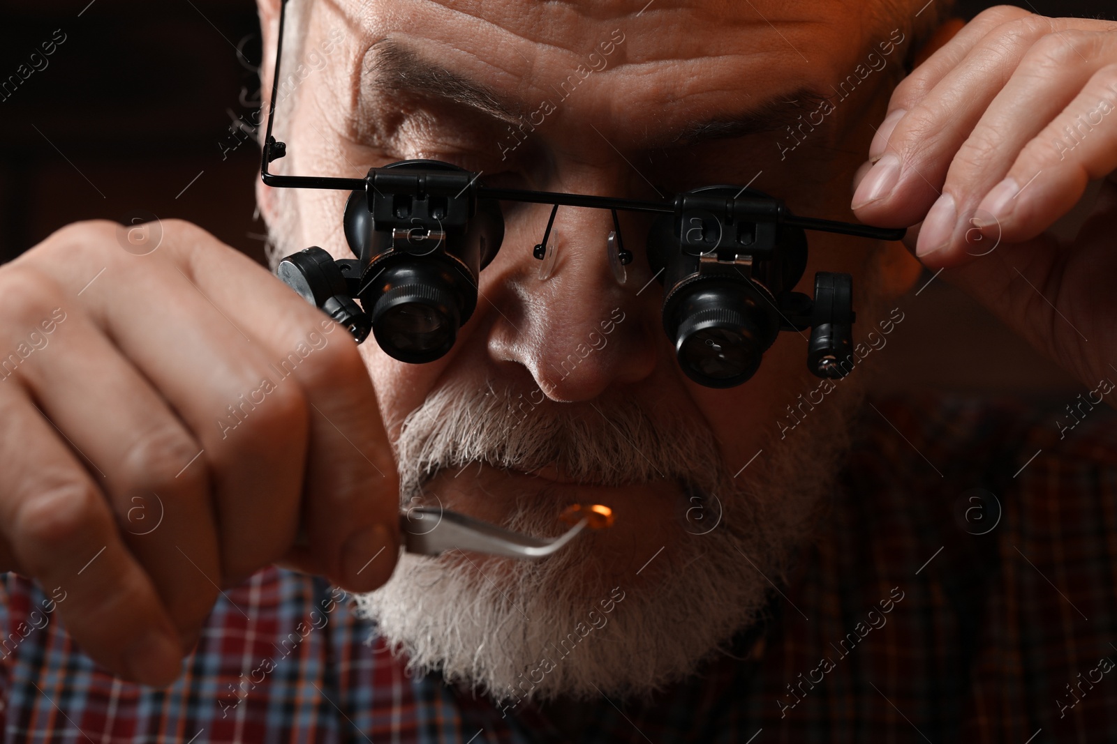 Photo of Professional jeweler working with gemstone, closeup view